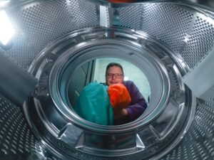 A man washes dirty clothes in a washing machine